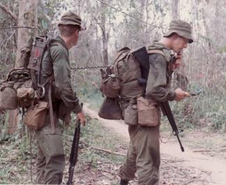 The  point man of "D" Company , 5th Battalion, Royal Australian Regiment, uses his radioman's PRC-25 to contact the section leader during an operation north of Nui Dat.