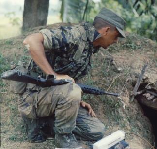 A tiger stripe clad reconnaissance team member of the 101st Airborne prepares to blow a bunker as part of Operation Van Buren.