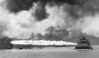 An early flame-throwing Tango Boat (ATC-92-2) unleashes its deadly fire on the riverbank near Dong Tam in the Mekong Delta.