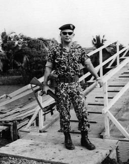 First Lieutenant Rick Caplin, XO of Special Forces Detachment A-321, stands by a wooden bridge over the canal at Vinh Binh in the Mekong Delta.