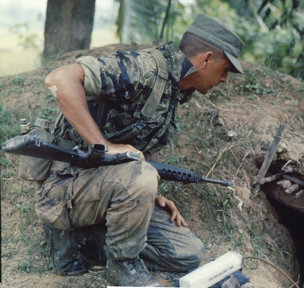 A tiger stripe clad reconnaissance team member of the 101st Airborne prepares to blow a bunker as part of Operation Van Buren.
