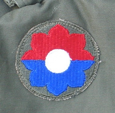 The shoulder sleeve insignia of the 9th Infantry Division was an octofoil horizontally divided into red and blue halves.