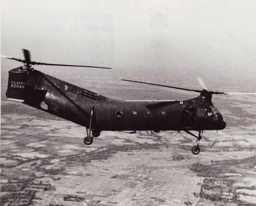 A CH-21 Shawnee (“Flying Banana”) Helicopter from the 57th Helicopter Company flies over a Viet Cong area during a routine mission.