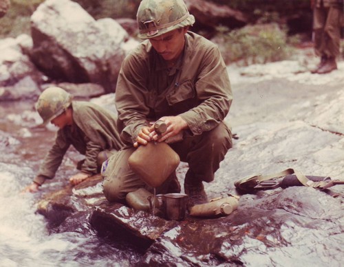Infantrymen of 173d Airborne Brigade fill their 2-quart collapsible canteens with water, north of An Khe in II Corps.