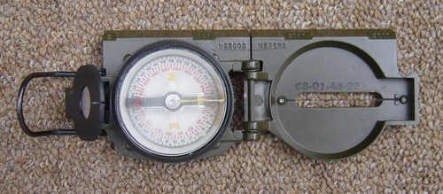 1966 Lensatic Compass with a straight edge graduated at 1:25,000 meters.