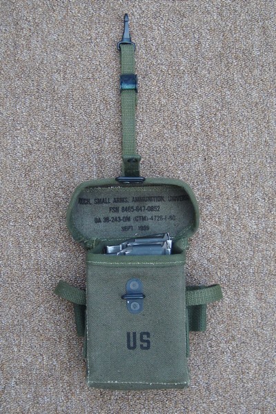 The M1956 Universal Small Arms Ammunition Pouch's supporting strap was attached to the metal loop on each suspender strap.