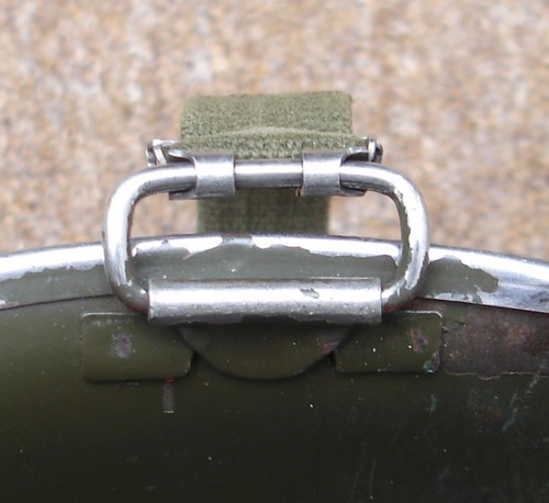 The webbing chinstrap clipped to hinged loops on either side of the M1 Helmet.