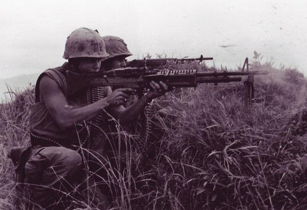 A machine gunner and a rifleman from the 5th Marine Regiment fire at the enemy near the DMZ in Vietnam.