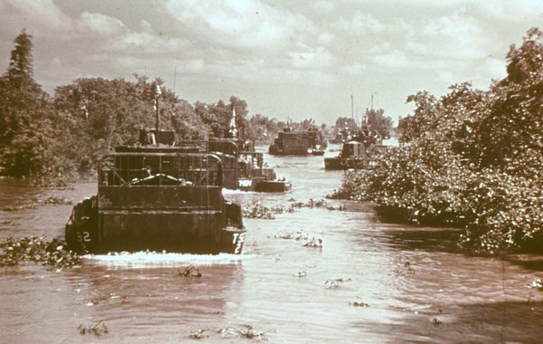 A column of Armored Troop Carriers (ATC) head down a hibiscus choked river in the Mekong Delta.