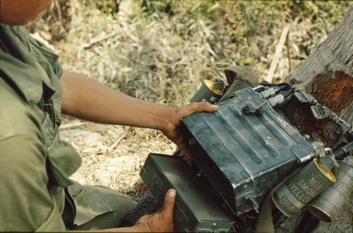 Radio / Telephone Operator (RTO) of the 9th Infantry Division changes the battery of his PRC-25.