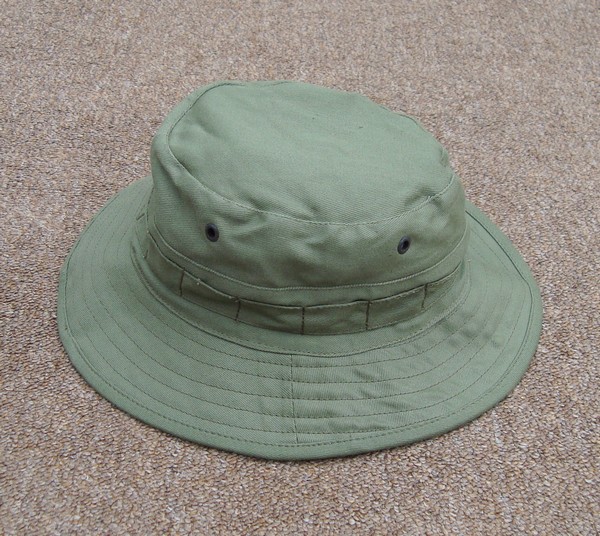 Australian Giggle Hat was made from  jungle green cotton twill and featured a headband for inserting natural camouflage.