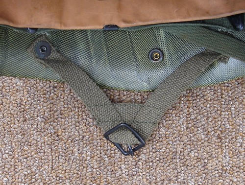 The P64 parachutist liner was equipped with two female snap fasteners, one on each side of the shell, which mated with the male snap fasteners on the helmet chin strap.