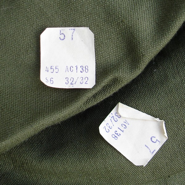 These unissued USMC P56 trousers still have the original cutter's tags.